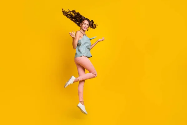 Teljes hosszúságú fotó vidám pozitív fiatal nő ugrik fel légy haj kezét élvezze elszigetelt sárga színű háttér — Stock Fotó