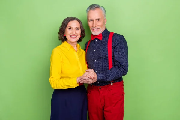 Foto de dos pacíficos pensionistas abrazados disfrutan de la discoteca de los años 60 aislada sobre fondo de color verde — Foto de Stock