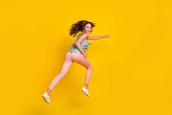 Full storlek foto av glada ung kvinna hoppa upp springa pekfinger tomt utrymme försäljning isolerad på gul färg bakgrund — Stockfoto
