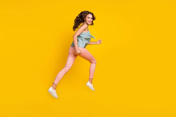 Helkroppsfoto av glad ung kvinna hoppa upp köra tomt utrymme nyheter isolerad på gul färg bakgrund — Stockfoto