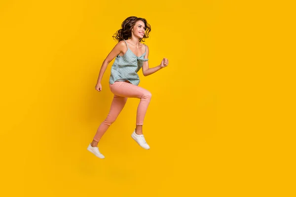 Full längd foto av positiva drömmande kvinna hoppa upp springa ser tomt utrymme försäljning isolerad på gul färg bakgrund — Stockfoto