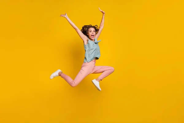 Foto de cuerpo completo de alegre mujer loca positiva saltar levantar las manos activo aislado sobre fondo de color amarillo —  Fotos de Stock