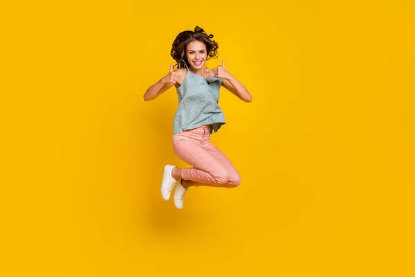 Full body foto van vrolijke jonge vrolijke vrouw springen up show duim-up koel geïsoleerd op gele kleur achtergrond — Stockfoto