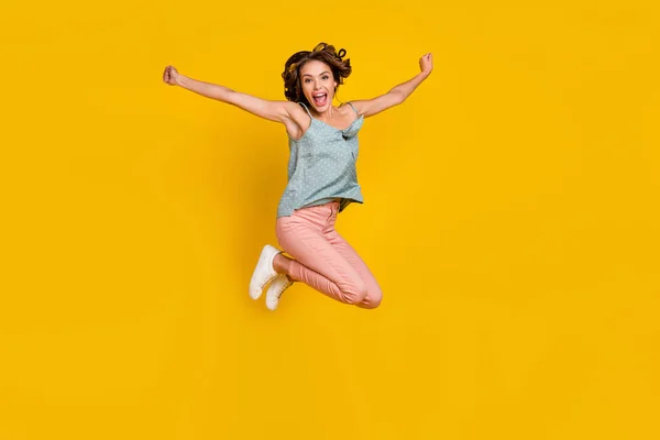 Volledige lengte foto van verbaasd opgewonden vrolijke vrouw spring omhoog verhogen handen goed humeur geïsoleerd op gele kleur achtergrond — Stockfoto