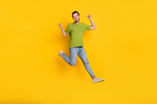Foto de cuerpo completo de hombre joven saltar regocijarse victoria puños manos objetivo impresionante aislado sobre fondo de color amarillo —  Fotos de Stock