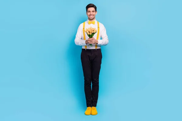 Foto seukuran penuh dari orang yang positif ramah memegang bunga segar tottish senyum terisolasi di latar belakang warna biru — Stok Foto