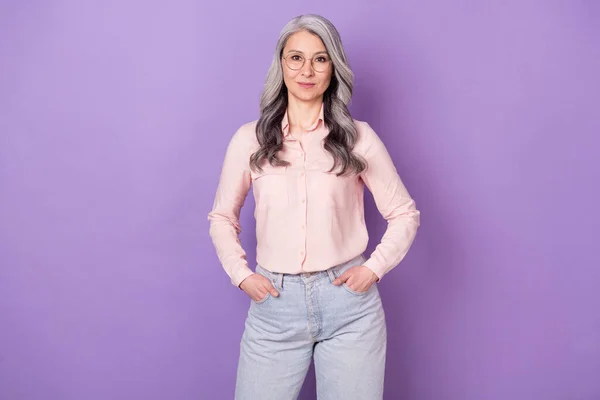 Portrét atraktivní obsah obchodnice expert drží ruce v kapsách izolované přes fialové barvy pozadí — Stock fotografie