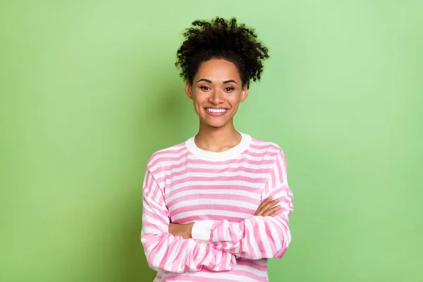 Φωτογραφία από θετικό χαριτωμένο όμορφη κυρία διπλωμένα χέρια γυαλιστερό λευκό χαμόγελο φορούν ριγέ πουκάμισο απομονωμένο πράσινο χρώμα φόντο — Φωτογραφία Αρχείου