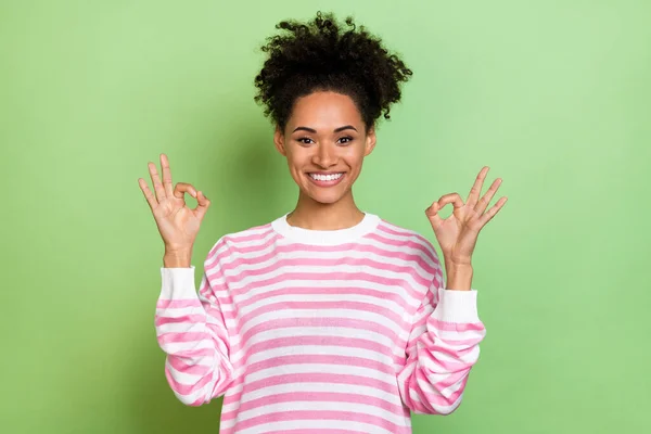 Fotografie rozkošný lesklý dáma oblečený růžový svetr ukazující dvě okey gesta izolované zelené barvy pozadí — Stock fotografie