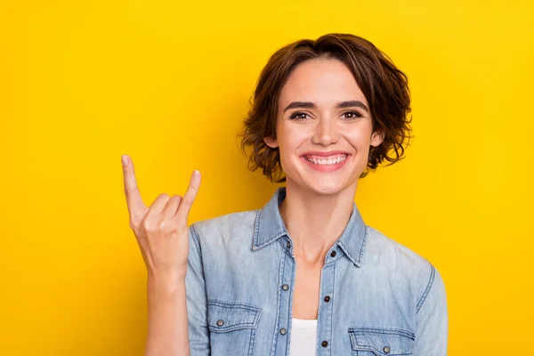 Фото молодой веселой девушки хорошее настроение показывают пальцы рок символ изолирован на желтом фоне цвета — стоковое фото