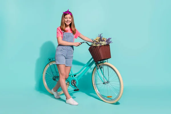 Retrato de perfil em tamanho completo de linda menina cesta de bicicleta flores silvestres isoladas no fundo de cor ciano — Fotografia de Stock