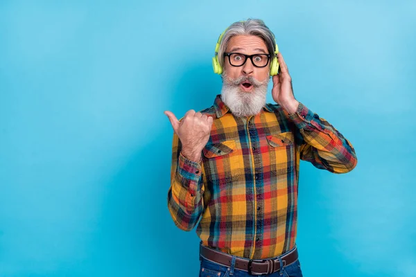 Photo de l'homme impressionné porter des lunettes chemise à carreaux profiter de la musique espace vide isolé fond de couleur bleue — Photo