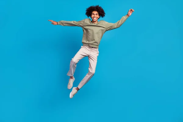 Full storlek foto av ung glad kille har kul hoppa upp glädje resa isolerad över blå färg bakgrund — Stockfoto
