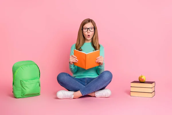 Fénykép a lenyűgözött lány viselni türkiz pulóver olvasás könyv iskolai kellékek elszigetelt rózsaszín szín háttér — Stock Fotó