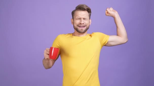 Guy stretch armen drinken aromatische latte geïsoleerde levendige kleur achtergrond — Stockvideo