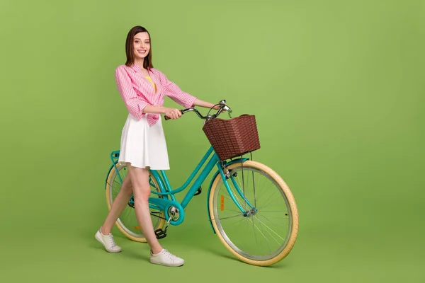 Tamanho total de jovem deslumbrante fêmea feminina viajando com passeio de fim de semana de bicicleta isolado no fundo de cor verde — Fotografia de Stock