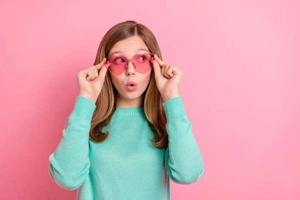 Foto di ragazza sognante indossare maglione turchese braccia occhiali cuore cercando spazio vuoto isolato colore rosa sfondo — Foto Stock