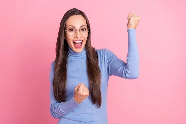 Foto de feliz senhora louca levantar punhos celebrar especificações de desgaste de realização azul gola alta isolado cor rosa fundo — Fotografia de Stock