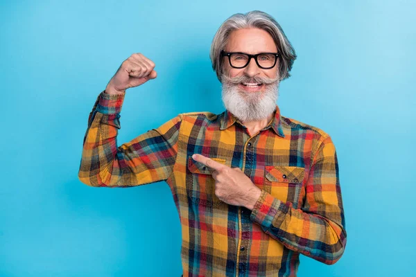 面白い自信を持って引退した男の写真は、指の腕の筋肉を指す再生シャツ眼鏡を着用隔離された青の色の背景 — ストック写真