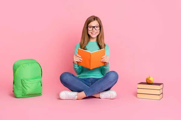 Foto av smart skola flicka klädd teal pullover sittande golv läsa bok leveranser isolerad rosa färg bakgrund — Stockfoto