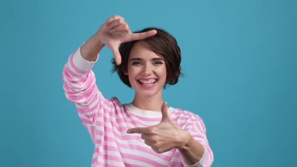 Lady, hogy a kezét lövés grimasz nyelv ki fülek elszigetelt kék szín háttér — Stock videók