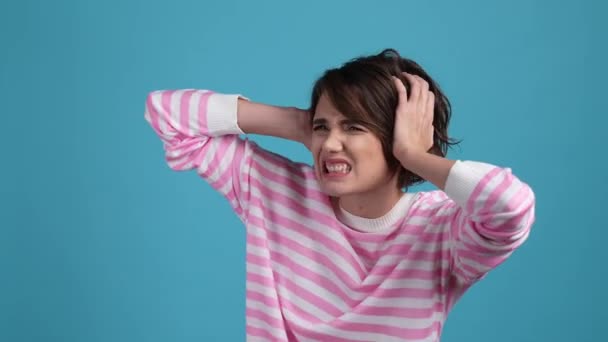 Frustrated lady hide ears deaf ask stop noise isolated blue color background — Stock Video