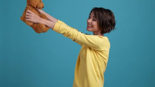 Bayan kürk hediyesini alır doldurulmuş hayvan oyunu izole edilmiş mavi arka plan — Stok video