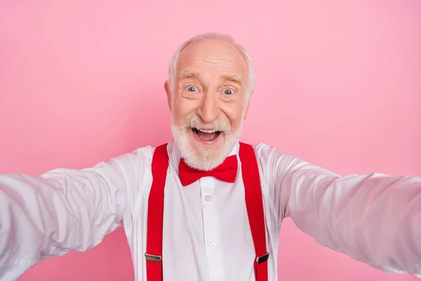 Autoportrait de séduisant homme aux cheveux gris gai s'amuser soirée festive de bonne humeur isolé sur fond rose couleur pastel — Photo
