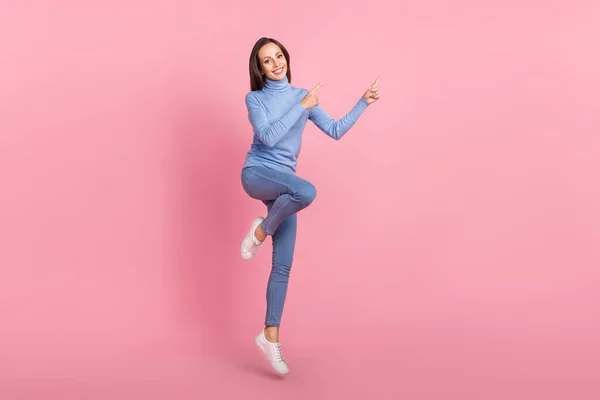 Фото веселих леді стрибати прямий палець порожній простір носити синій черепашка ізольований рожевий кольоровий фон — стокове фото