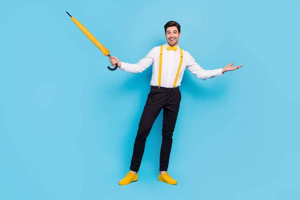 Full body portrait of cheerful friendly person hold umbrella hand invite isolated on blue color background