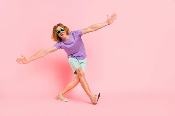 Lunghezza completa dimensione del corpo vista di attraente allegro ragazzo che balla a piedi avendo divertimento resto isolato su rosa pastello colore sfondo — Foto Stock