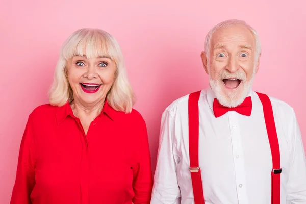 Portrait of attractive cheery funny amazed gray-haired couple great news reaction isolated over pink pastel color background