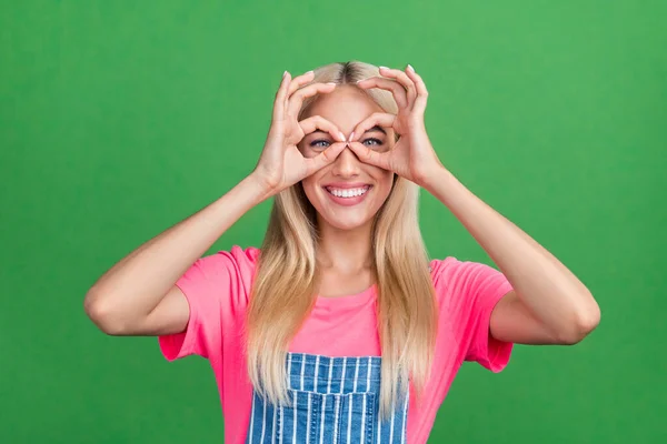Fotografie legrační šílené krásné přítelkyně dáma show dalekohled prsty nosit pruhované celkově izolované zelené barvy pozadí — Stock fotografie