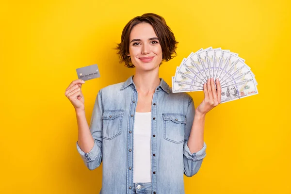 Foto van jonge vrouw houden bankkaart geld besparen winst advetrise geïsoleerd over gele kleur achtergrond — Stockfoto