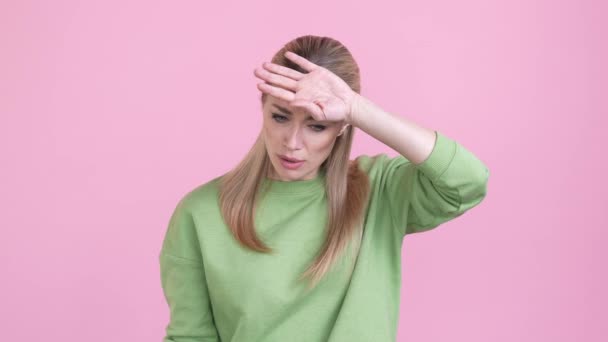 Gefrustreerde dame covid-19 pandemische migraine geïsoleerde pastel kleur achtergrond — Stockvideo