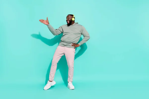 Longitud completa cuerpo tamaño vista de alegre atractivo chico moviendo baile hip hop ritmo pop aislado sobre brillante verde azulado color turquesa fondo — Foto de Stock