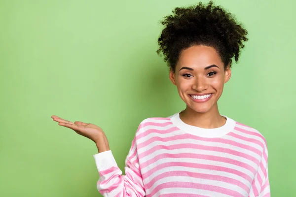 Foto de la agradable palmera dama alegre que presenta consejos de espacio vacíos usar camisa a rayas aislado fondo de color verde — Foto de Stock