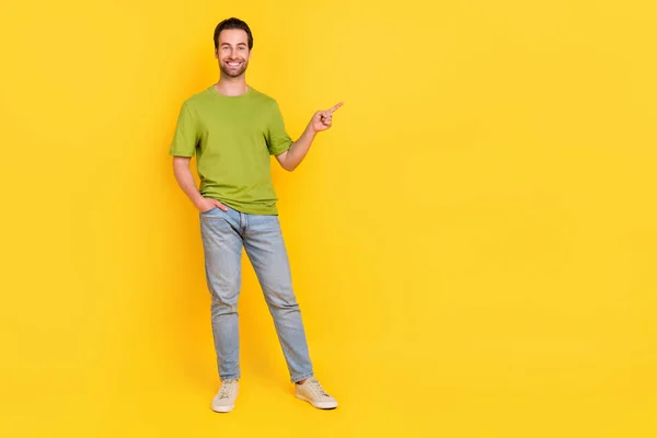 Full storlek foto av bra skägg ung kille index promo wear t-shirt jeans skor isolerad på gul färg bakgrund — Stockfoto