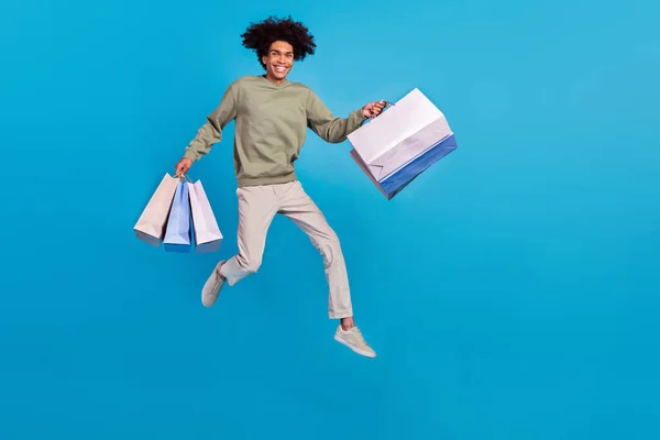 Фотографія повної довжини молодого чоловіка, енергійний стрибок торговий центр знижка ізольовані на синьому кольоровому фоні — стокове фото