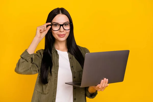 Foto da senhora milenar agradável segurar laptop desgaste óculos camisa cáqui isolado no fundo amarelo — Fotografia de Stock
