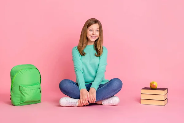 Foto di sognante ragazza della scuola vestito pullover verde acqua seduta gambe pavimento attraversato isolato colore rosa sfondo — Foto Stock
