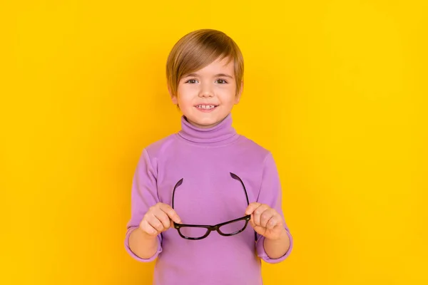 Fénykép bájos jó hangulatú kisfiú hold szemüveg látogatás szemész elszigetelt sárga színű háttér — Stock Fotó