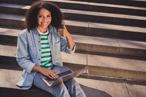 Portret van aantrekkelijke vrolijke bekwame meisje zitten op de trap met behulp van laptop tonen thumbup werken op afstand afstand buiten — Stockfoto