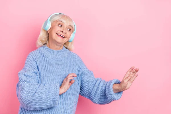 Retrato de atractiva mujer de pelo gris alegre escuchando bajo jazz soul disfrutando bailando aislado sobre fondo de color pastel rosa — Foto de Stock