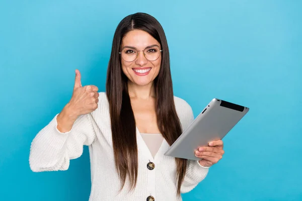 Zdjęcie pewnej siebie kobiety nosić białe okulary kardiganowe pokazujące kciuk do góry wpisując nowoczesne urządzenie odizolowany niebieski kolor tła — Zdjęcie stockowe