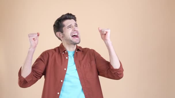 Веселый парень сжимать кулаки вверх выиграть счастливый джекпот изолированный пастельный цвет фона — стоковое видео