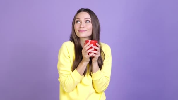 Positieve dame houden hete cappuccino geïsoleerde levendige kleur achtergrond — Stockvideo