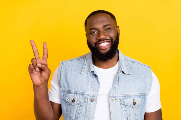 Portrait of attractive funky cheerful man wearing t-shirt showing v-sign isolated over bright yellow color background — Stock Photo, Image