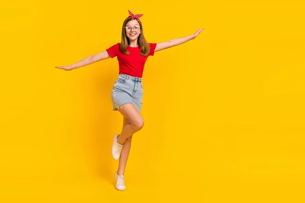 Повнорозмірна фотографія позитивної милої дівчини-підлітка танцює веселі руки літаючі крила ізольовані на жовтому кольорі — стокове фото