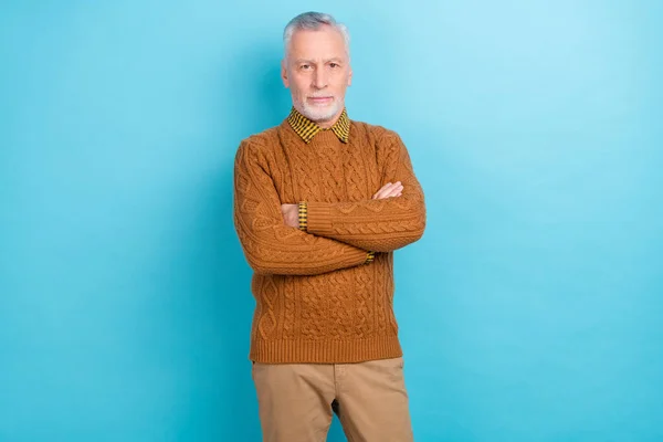 Foto de homem aposentado confiante atraente usar braços de camisola marrom dobrado sorrindo isolado fundo de cor azul — Fotografia de Stock